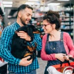 Happy,Couple,Buying,Toys,And,Food,For,Their,Dachshund,In