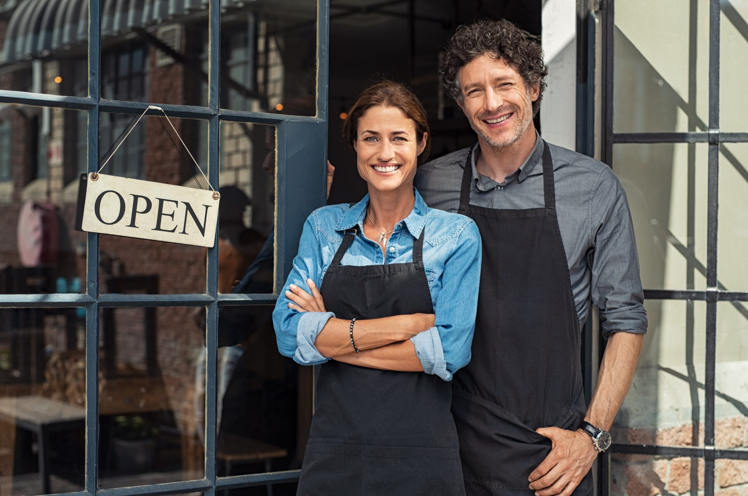 Two,Cheerful,Small,Business,Owners,Smiling,And,Looking,At,Camera