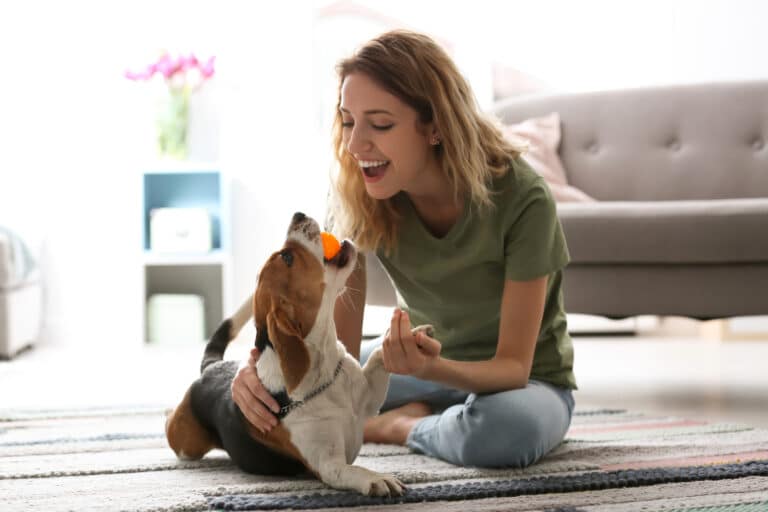 Young,Woman,Playing,With,Her,Dog,At,Home