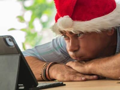 Man,With,Santa,Hat,Bored,And,Stressed,In,The,Office