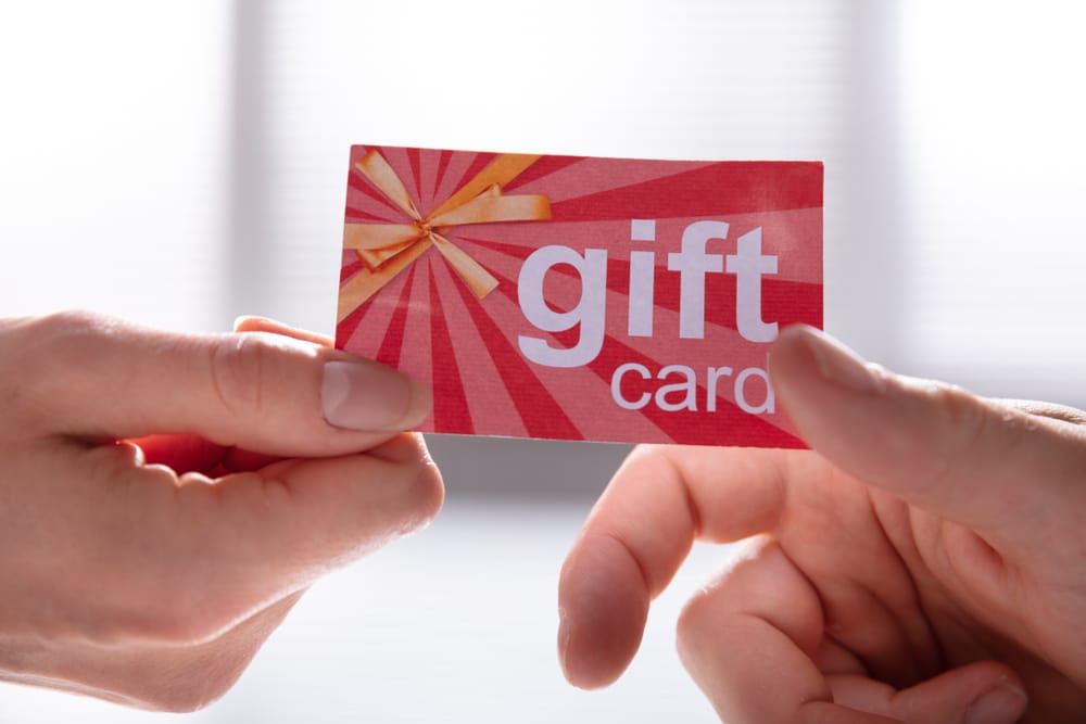 Close-up,Of,Female,Hand,Giving,Gift,Card,To,Her,Male