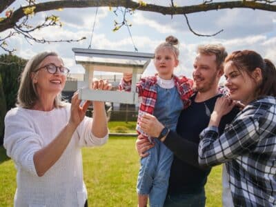 Cheerful,Senior,Woman,Putting,Bread,At,Birdhouse,While,Feeding,Birds
