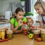 Family,Canning,Vegetables,In,Jars,In,The,Kitchen.,Selective,Focus.