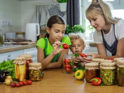 Family,Canning,Vegetables,In,Jars,In,The,Kitchen.,Selective,Focus.