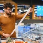 Customer,Checking,An,Extensive,Grocery,Receipt,While,Shopping,In,A